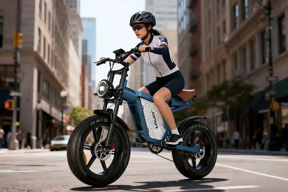 Female rider cycling blue Jansno X60 retro fat tire electric bike on busy city street surrounded by urban buildings.