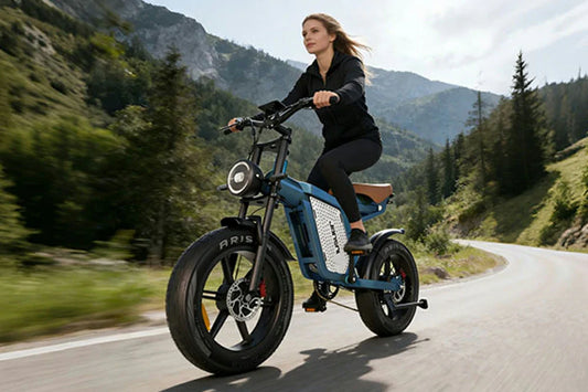Dynamic mountain road lifestyle shot of woman riding retro blue Jansno X60 fat tire electric bike on winding forest mountain highway.
